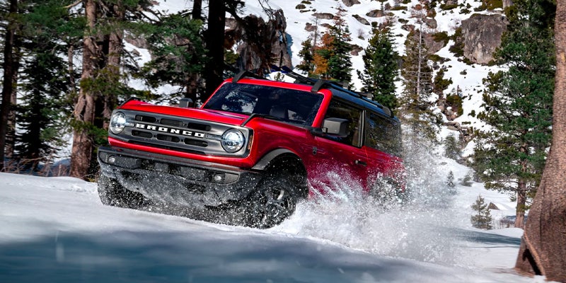 2023 Ford Bronco in red driving through the snow