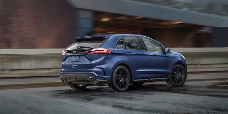 A dark blue 2024 Ford Edge driving through the streets of Norwood, MA